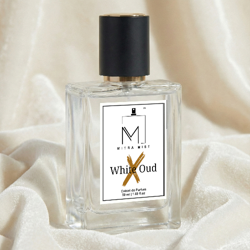 Perfume bottle labeled 'White Oud' by Mitra Mist on a soft fabric background